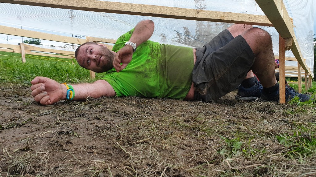 Crawling through a muddy obstacle course under a low net